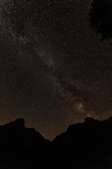 Milky Way over Mountain Silhouettes - Starry Night Sky and Galactic Core Above Dark Peaks
