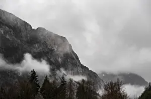 Framed Print : Misty mountains with fog rolling over forested slopes under cloudy skies along the lower mainland coast in British