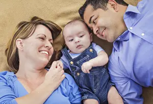 mixed-race family playing face up on the blanket