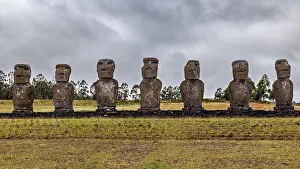 Eight Moai statues in a line on Easter Island against a cloudy sky