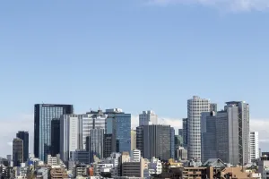 Modern architecture, view over the rooftops of the city to the glass facades of skyscrapers against a blue sky