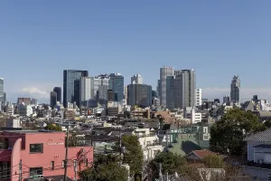 Modern architecture, view over the rooftops of the city to the glass facades of skyscrapers against a blue sky