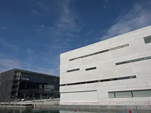 Modern buildings on the waterfront under a blue sky with scattered clouds