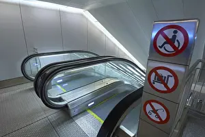 Modern escalators with prohibition signs and lighting