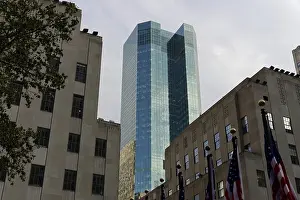 Modern glass building amidst older architecture under a grey sky