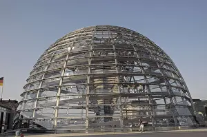 Modern glass dome of the Reichstag building in Berlin with visitors in bright daylight