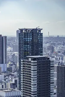 Framed Print : A modern high-rise dominates the skyline of a city with blue sky in the background