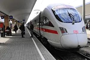 Modern ICE train at the railway station in white with red stripes