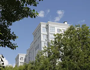 Modern residential building surrounded by green trees