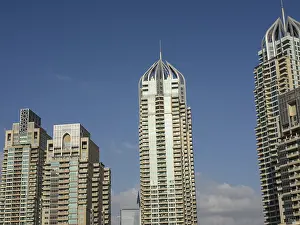 Three modern skyscrapers with architectural details rise into the sky