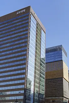 Two modern skyscrapers with glass facades against clear blue sky