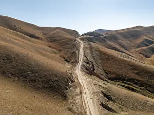 Moldo-Ashuu Pass, rutted road between yellow hills