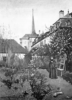 In the monastery garden, man wearing a monk's clothes stands in the garden and reads in a book