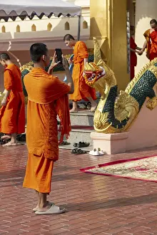 Monk in front of a Buddha statue