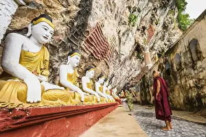 Monk looking at the seated Buddha statues