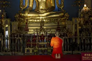 Monk meditating in front of the Phra Buddha Chinnarat