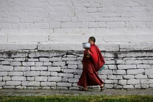Monk walking through the monastery courtyard in Jampey Lhakhang Temple