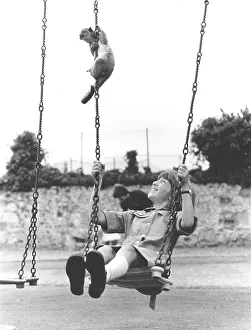 Monkey and child on a swing, England