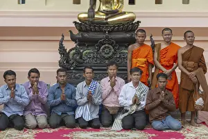 Monks and Laotians in front of a Buddha statue
