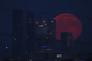 The full moon passes over the Frankfurt banking skyline