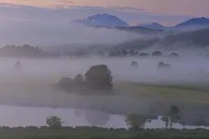 Morning fog in front of a mountain landscape