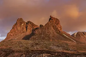 Morning light and clouds over steep mountains and rocks