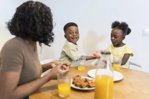 Mother and children enjoying breakfast together at the dining table