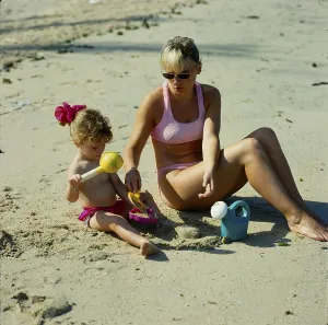 Mother and daughter 2 years on the sandy beach