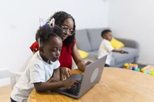 Mother and daughter using laptop computer at home
