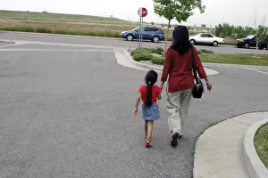 Mother and daughter walking on road