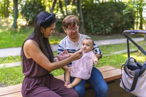 Mother feeding her baby girl solid food