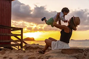 Mother having fun with her son at sunset in Cala Comte beach on the island of Ibiza