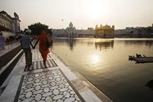 Mother and son walking marble design around the holy water pool bathing ghat
