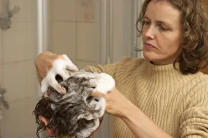 Mother washes her child hair with lice shampoo