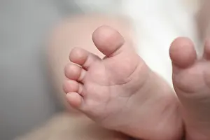 Mothers hands holding little newborn baby feet