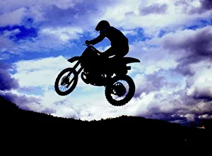 Motocross rider jumping, backlight