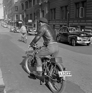 Motorcyclist in the 1950s. A young man on his motorcycle using the kick to start the engine