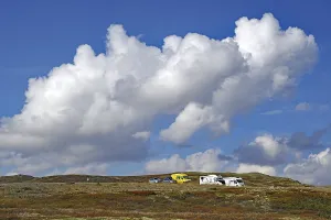 Motorhomes on a hilly landscape under large