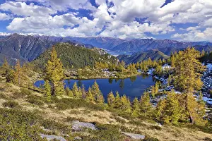 Mountain lake surrounded by autumnal larches
