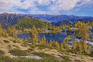Mountain lake surrounded by autumnal larches