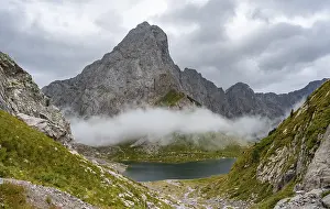 Mountain lake Wolayersee and rocky cloudy mountains