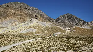Mountain landscape with a path surrounded by rocky hills and clear sky