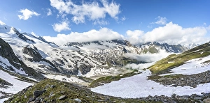 Mountain landscape with snow fields and high fog in the valley