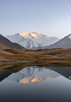Mountain landscape at sunset, mountains reflected in a small mountain lake