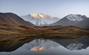 Mountain landscape at sunset, mountains reflected in a small mountain lake