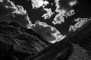 Mountain path with climber in Val Belver with cloudy sky