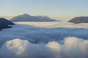 Mountain Peak Above Cloudscape with Sunlight and Clear Sky in Lugano