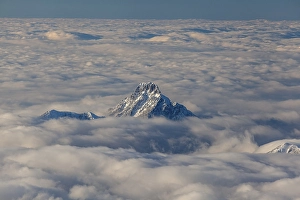 Mountain peak above high fog, evening light