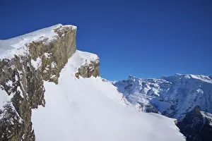 Mountain peak with snow-covered rocks under a clear blue sky