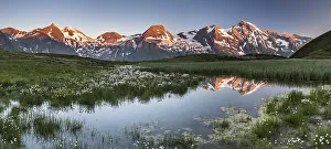 Mountain peaks are reflected in a small pond